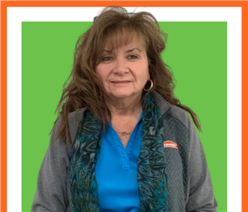 Marilyn, SERVPRO female employee in front of a green sign