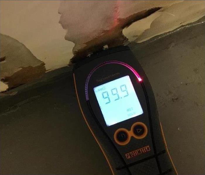 moisture meter reading 99.9 percent moisture on a wall in Orlando, FL